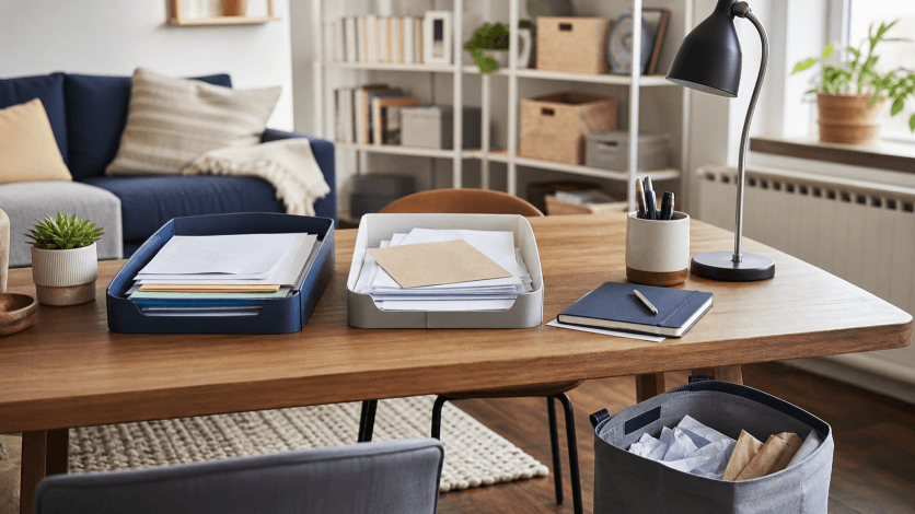 A small desk with papers sorted into simple trays
